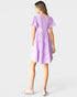 Woman wearing a purple dress on a light gray background