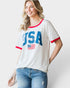 Woman wearing a white t-shirt with 'USA' and an American flag design on a plain background