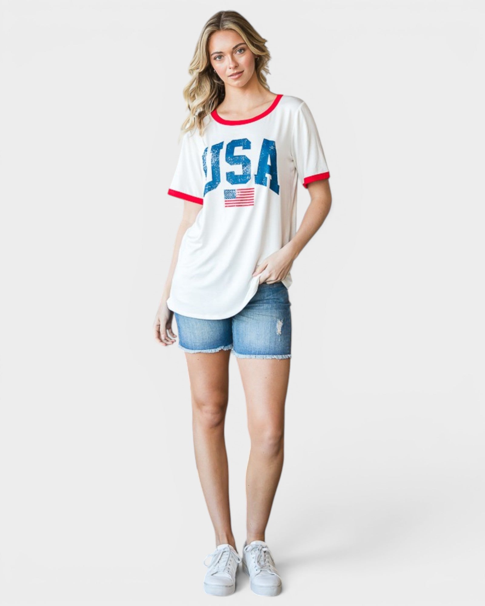 Woman wearing a white t-shirt with 'USA' print and denim shorts on a white background