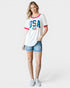Woman wearing a white t-shirt with 'USA' print and denim shorts on a white background
