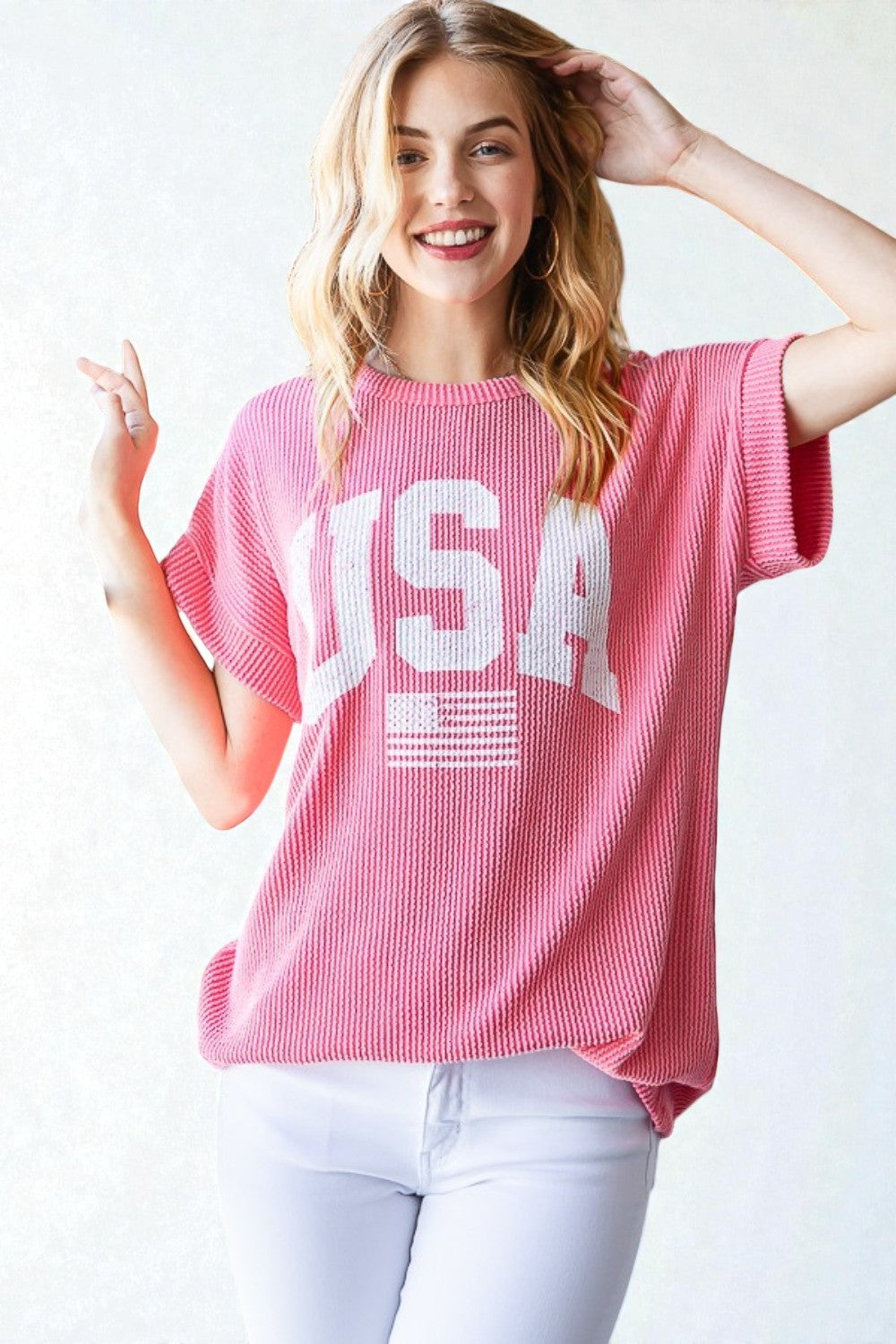 Woman wearing a pink 'USA' t-shirt with a white background