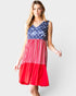Woman wearing a dress with American flag design on a plain background