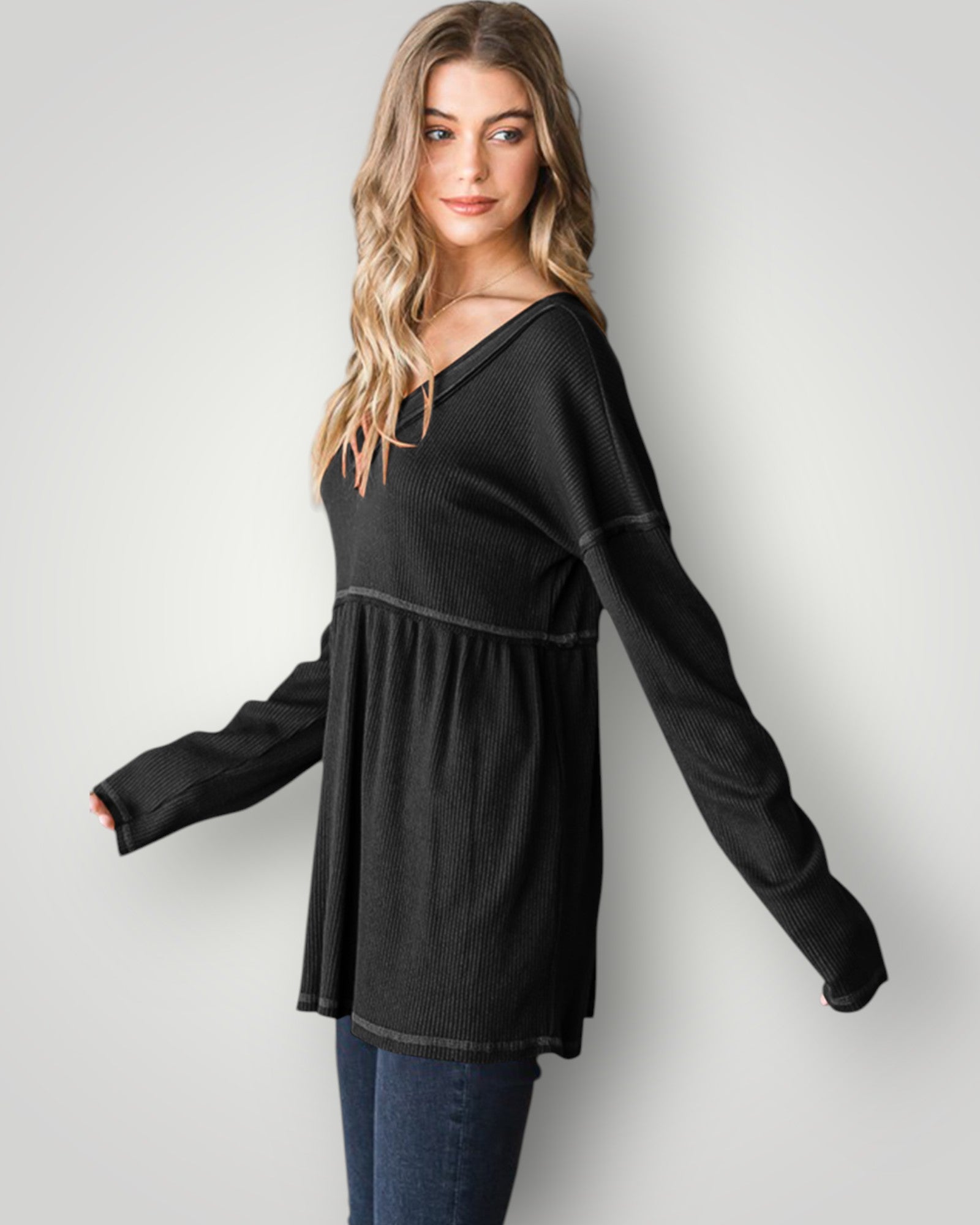 Woman wearing a black long-sleeve top against a white background