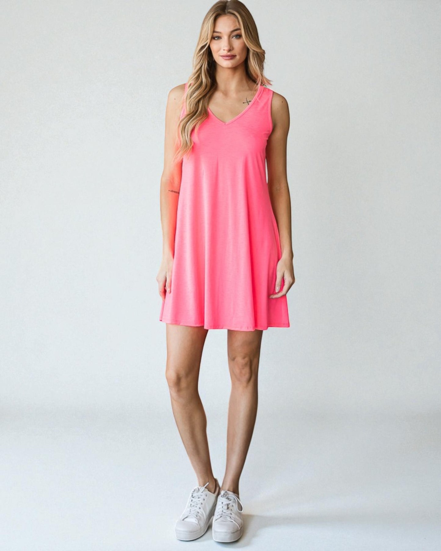 Woman wearing a pink sleeveless dress on a white background