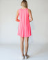 Woman wearing a pink sleeveless dress against a white background