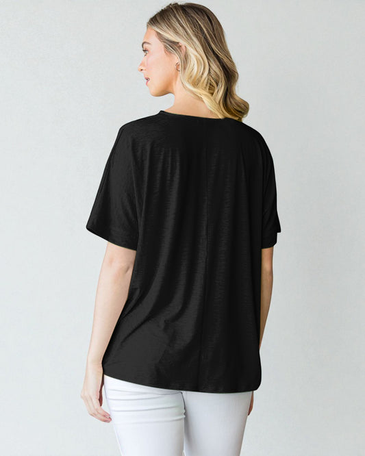 Woman wearing a black oversized t-shirt against a plain background