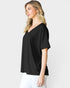 Woman wearing a black V-neck t-shirt against a white background