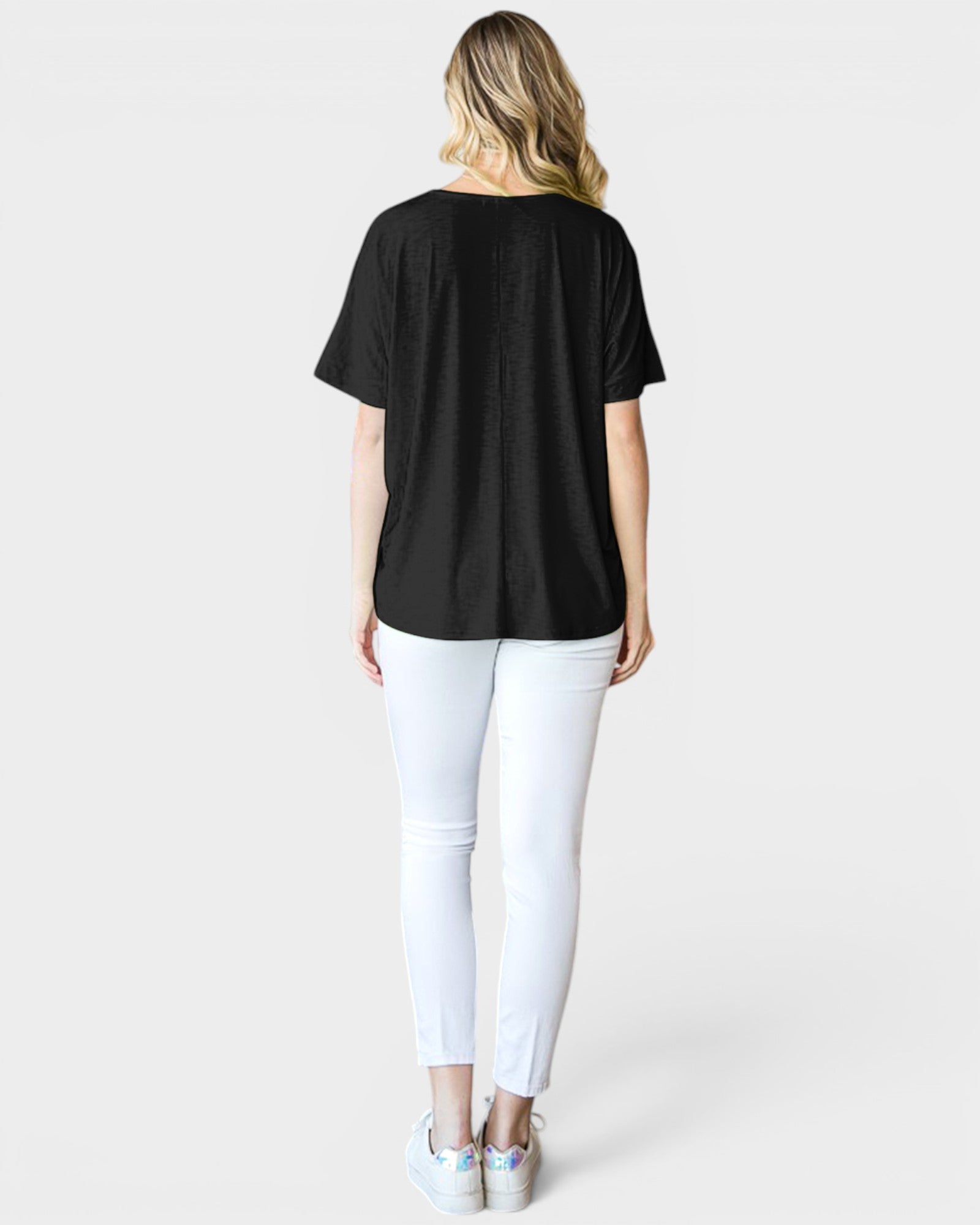 Person wearing a black t-shirt and white pants on a plain background