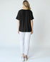 Person wearing a black t-shirt and white pants on a plain background