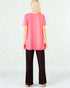 Person wearing a pink top and black pants against a light background