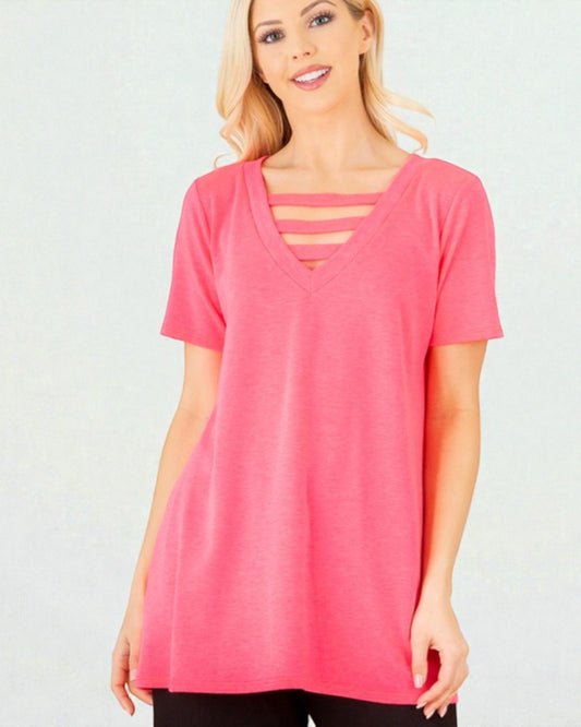 Woman wearing a pink t-shirt with cut-out details on a white background