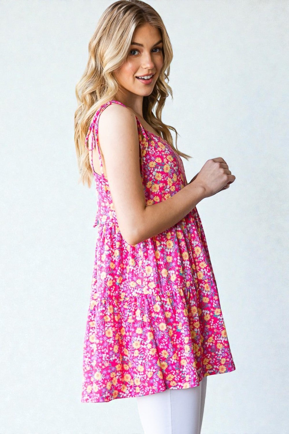 Woman wearing a pink floral dress against a white background