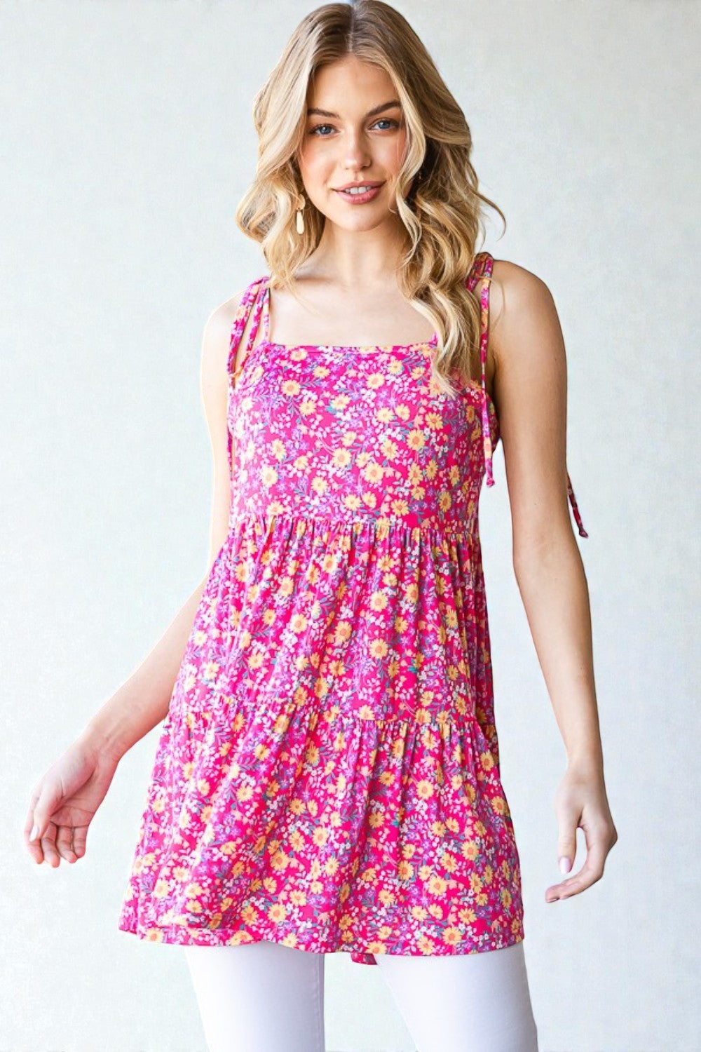 Woman wearing a pink floral dress against a white background