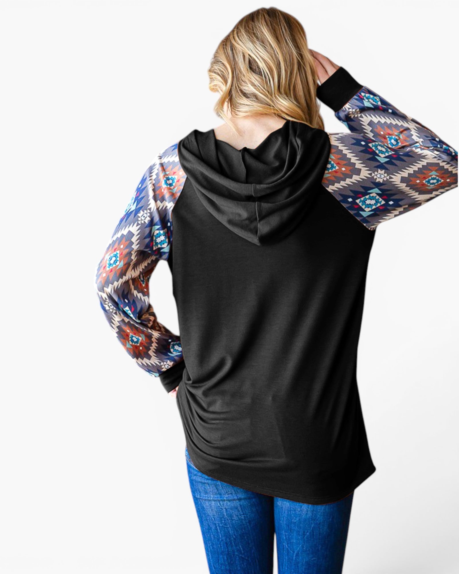 A woman shown from the back wearing a black long-sleeve hoodie with colorful geometric patterned sleeves, paired with blue jeans, against a plain white background.