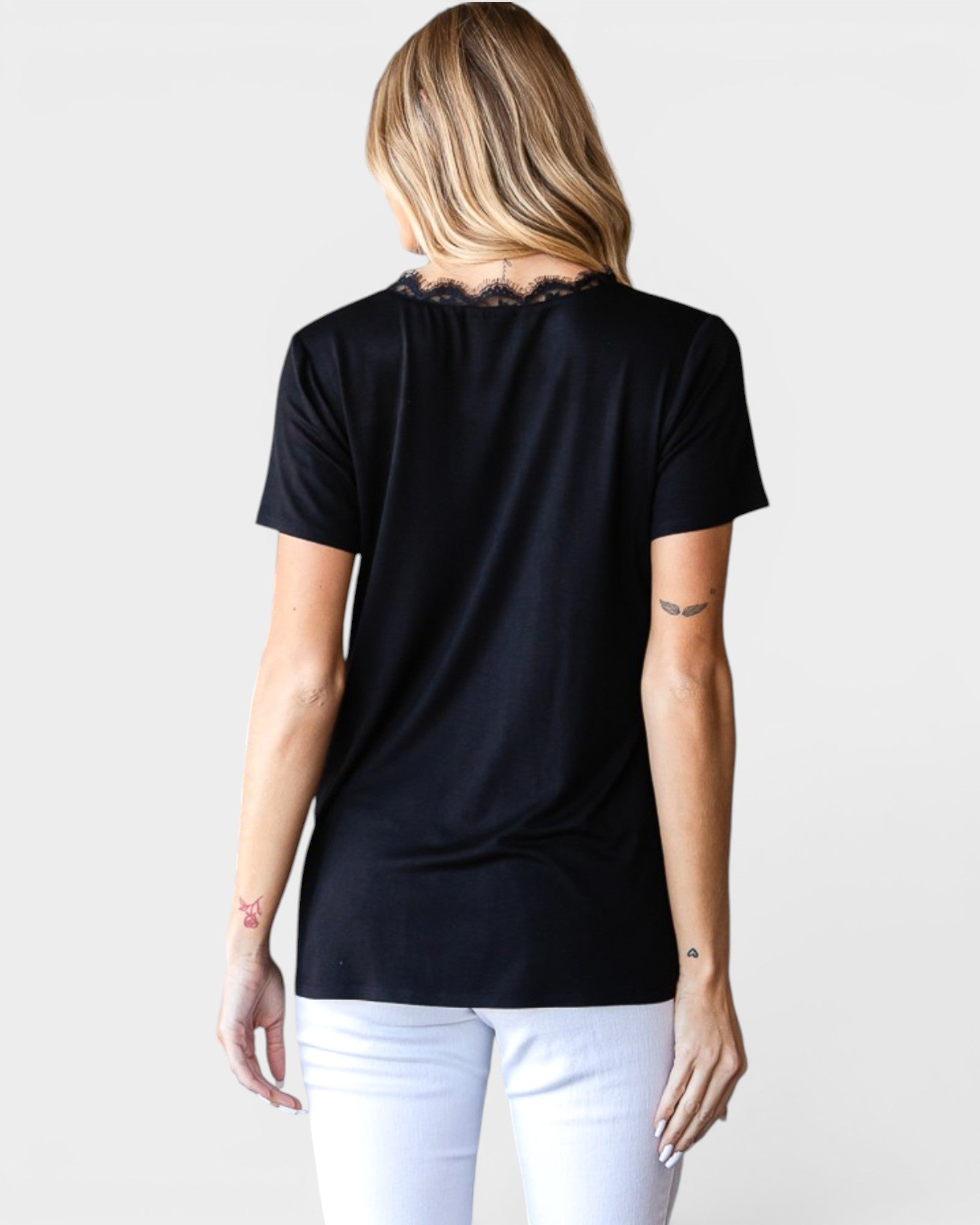 Person wearing a black t-shirt and white pants on a plain background