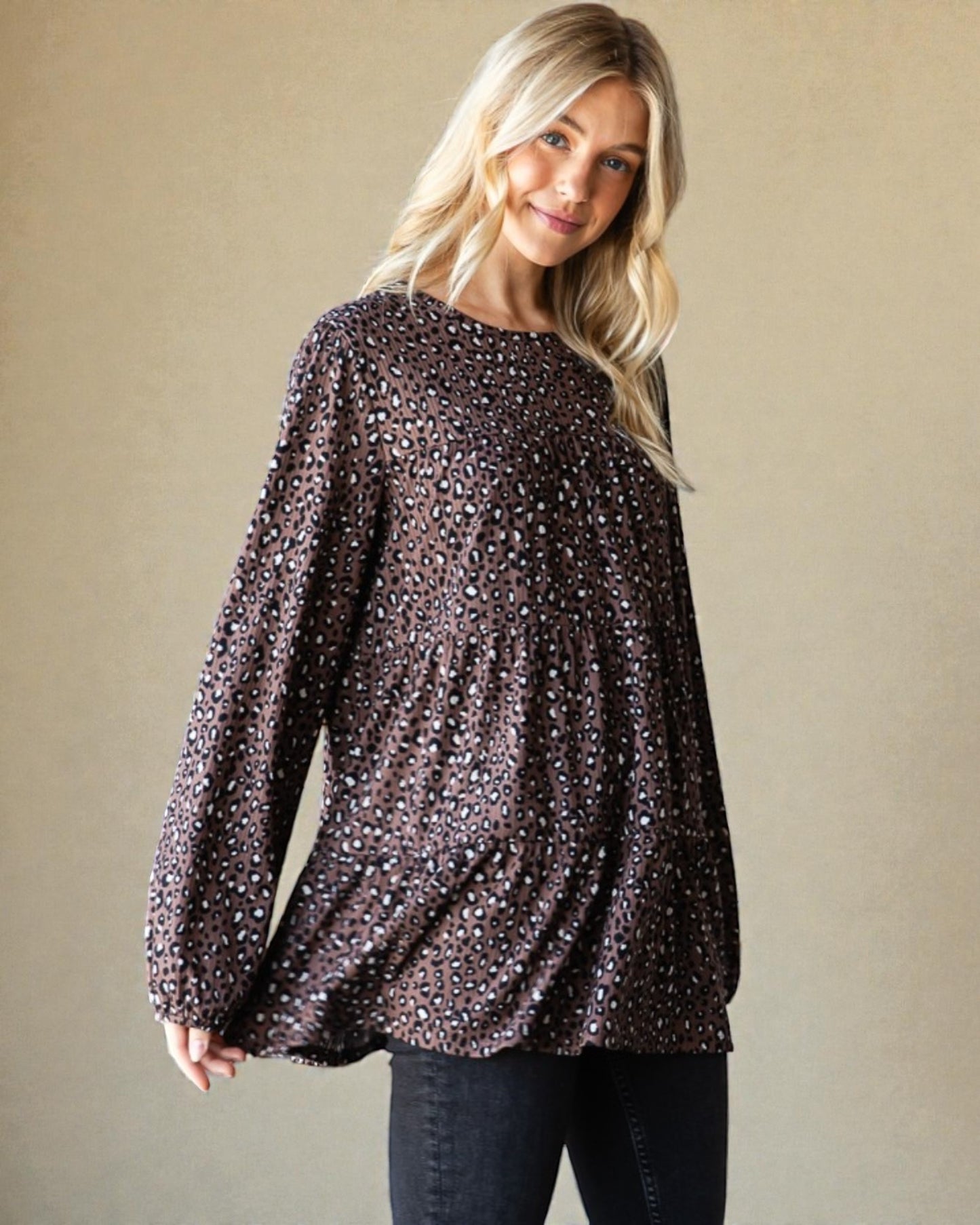 Woman wearing a sequin blouse against a beige background