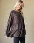Woman wearing a sequin blouse against a beige background