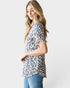 Woman wearing a leopard print top and blue jeans on a white background
