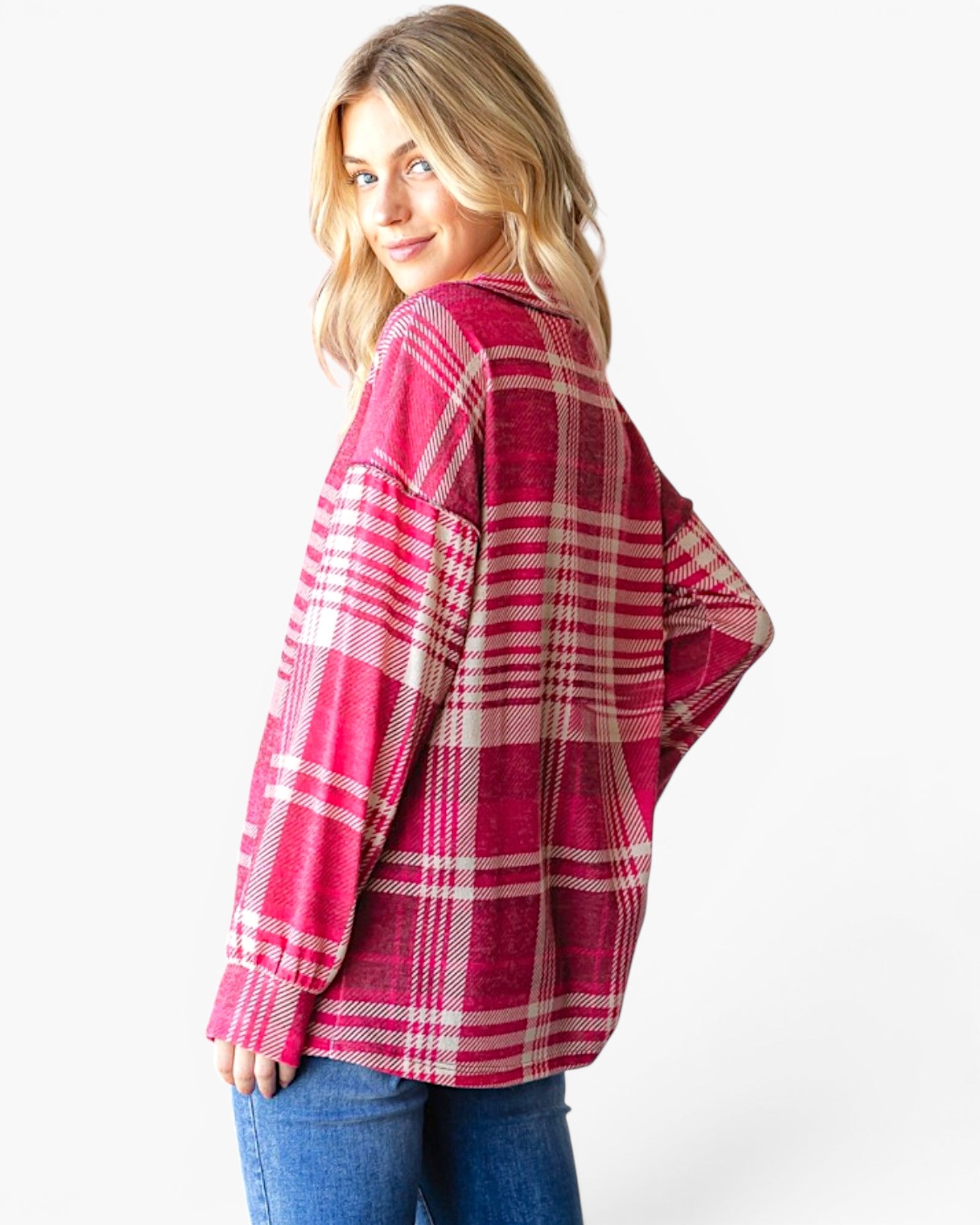 A woman wearing an oversized pink and white plaid flannel shirt, shown from a three-quarters back view against a plain white background.