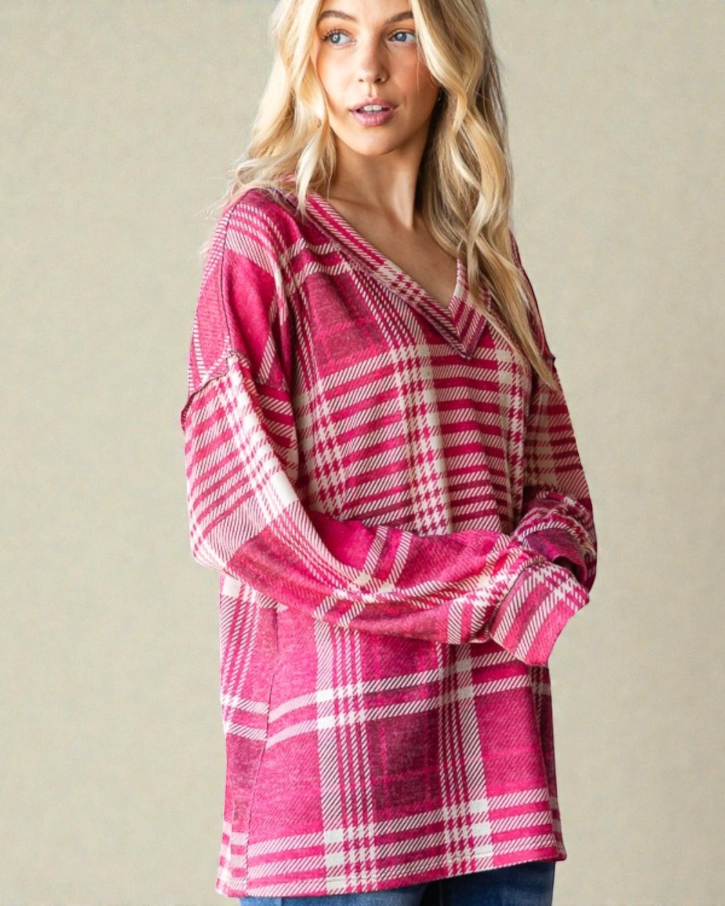 Woman wearing a pink plaid dress against a beige background