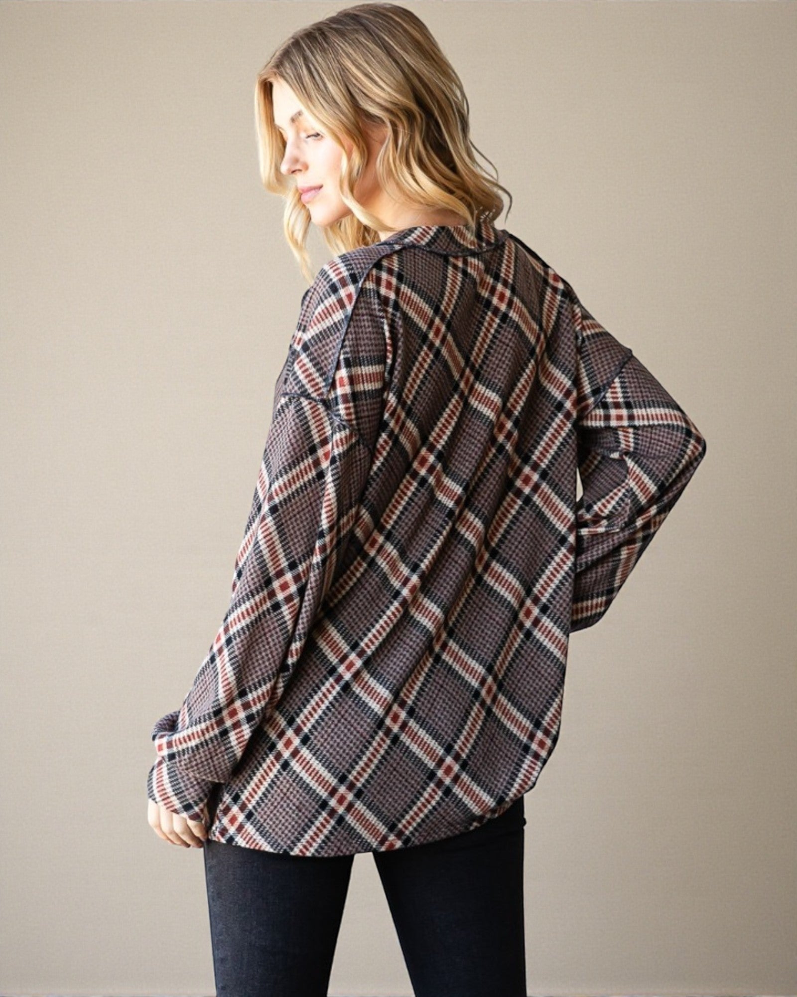 Woman wearing a plaid shirt against a plain background