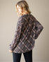 Woman wearing a plaid shirt against a plain background