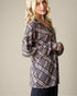 Woman wearing a plaid shirt against a plain background