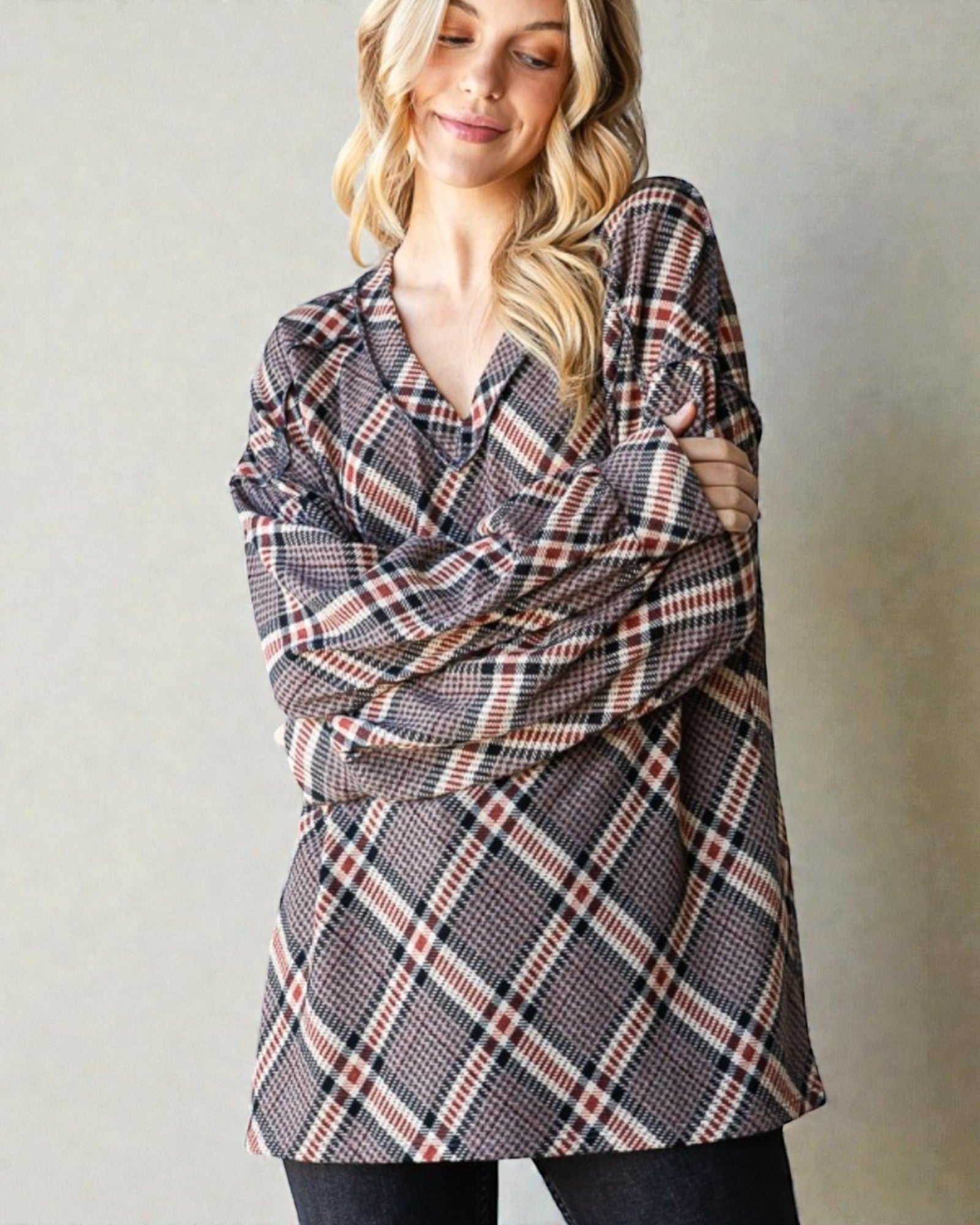 Woman wearing a plaid shawl over her shoulders against a plain background
