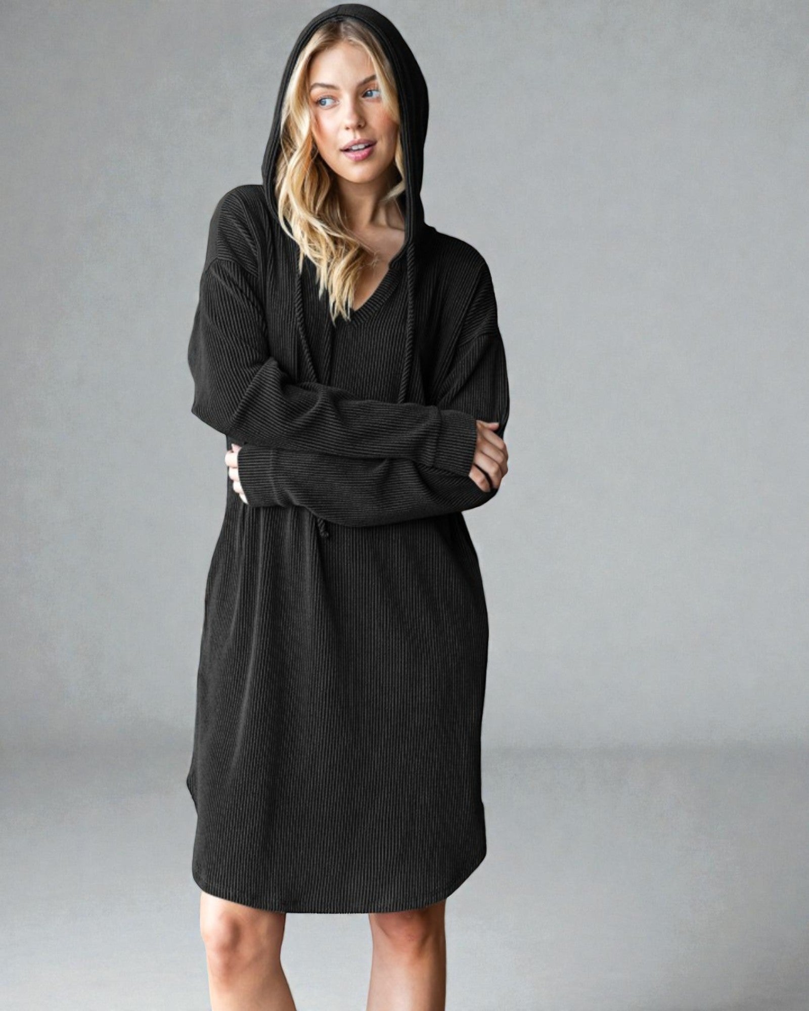 Woman wearing a black hooded dress against a gray background