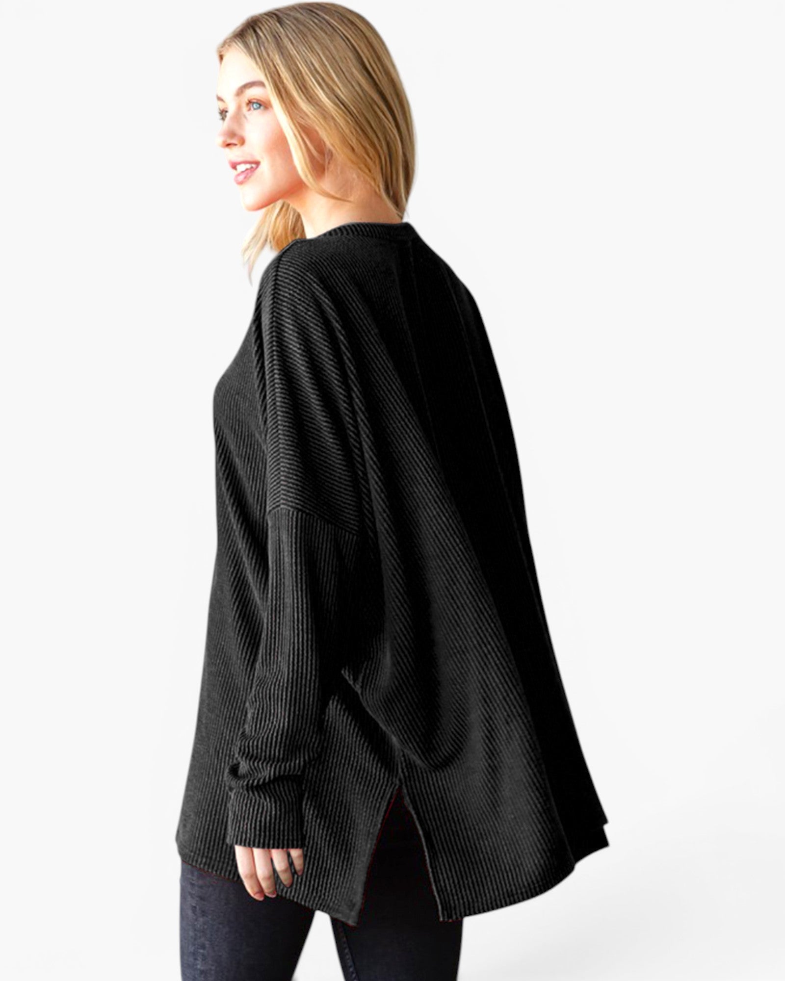 A woman wearing a black long-sleeve waffle-knit sweater, shown from a side-back angle against a plain white studio background.