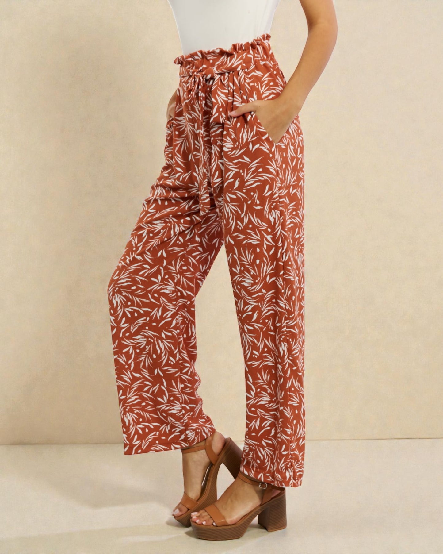 Person wearing red and white patterned pants on a beige background