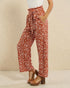 Person wearing red and white patterned pants on a beige background