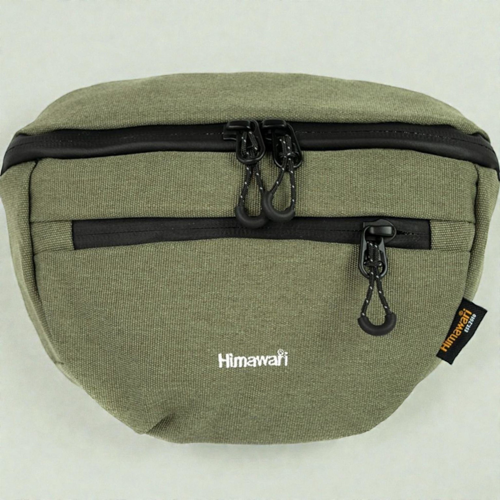 Green waist bag with black zippers and a visible brand tag on a white background