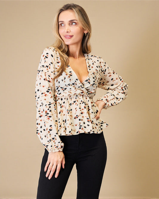 Woman wearing a patterned blouse with a beige background