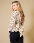 Woman wearing a patterned blouse with a plain background