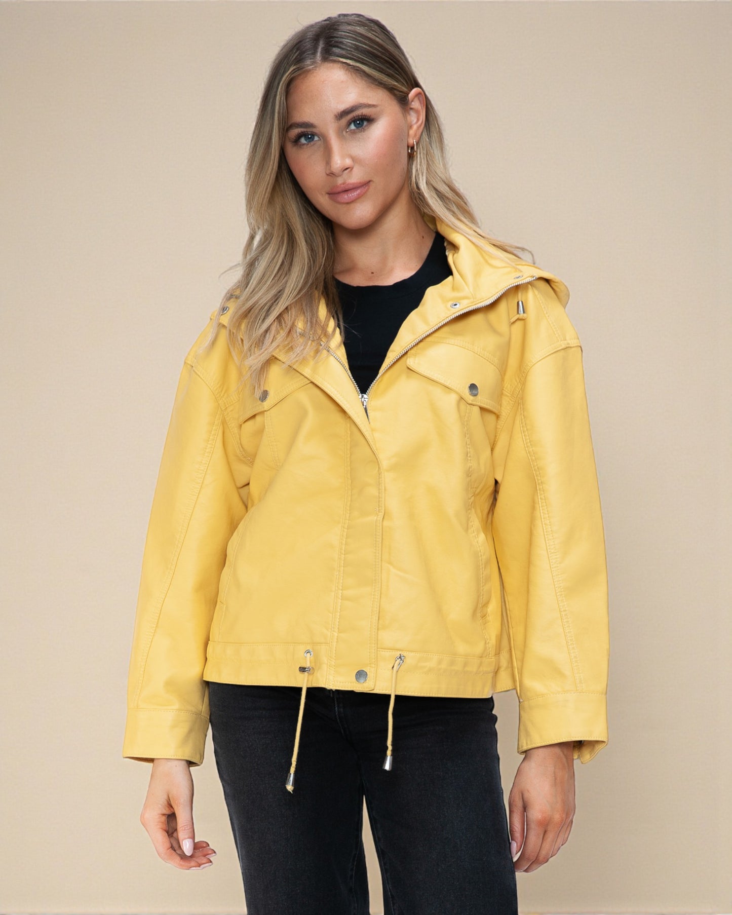 Woman wearing a yellow jacket against a beige background