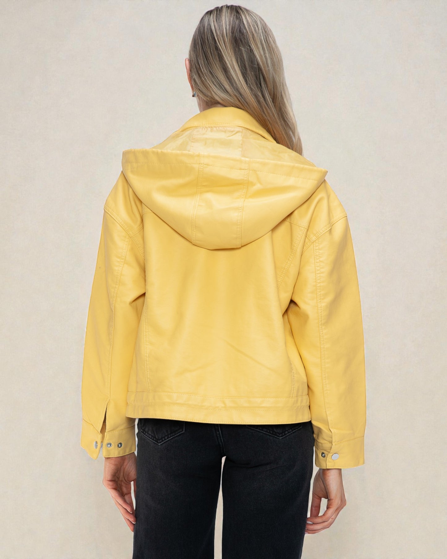 Person wearing a yellow jacket with a hood on a plain background