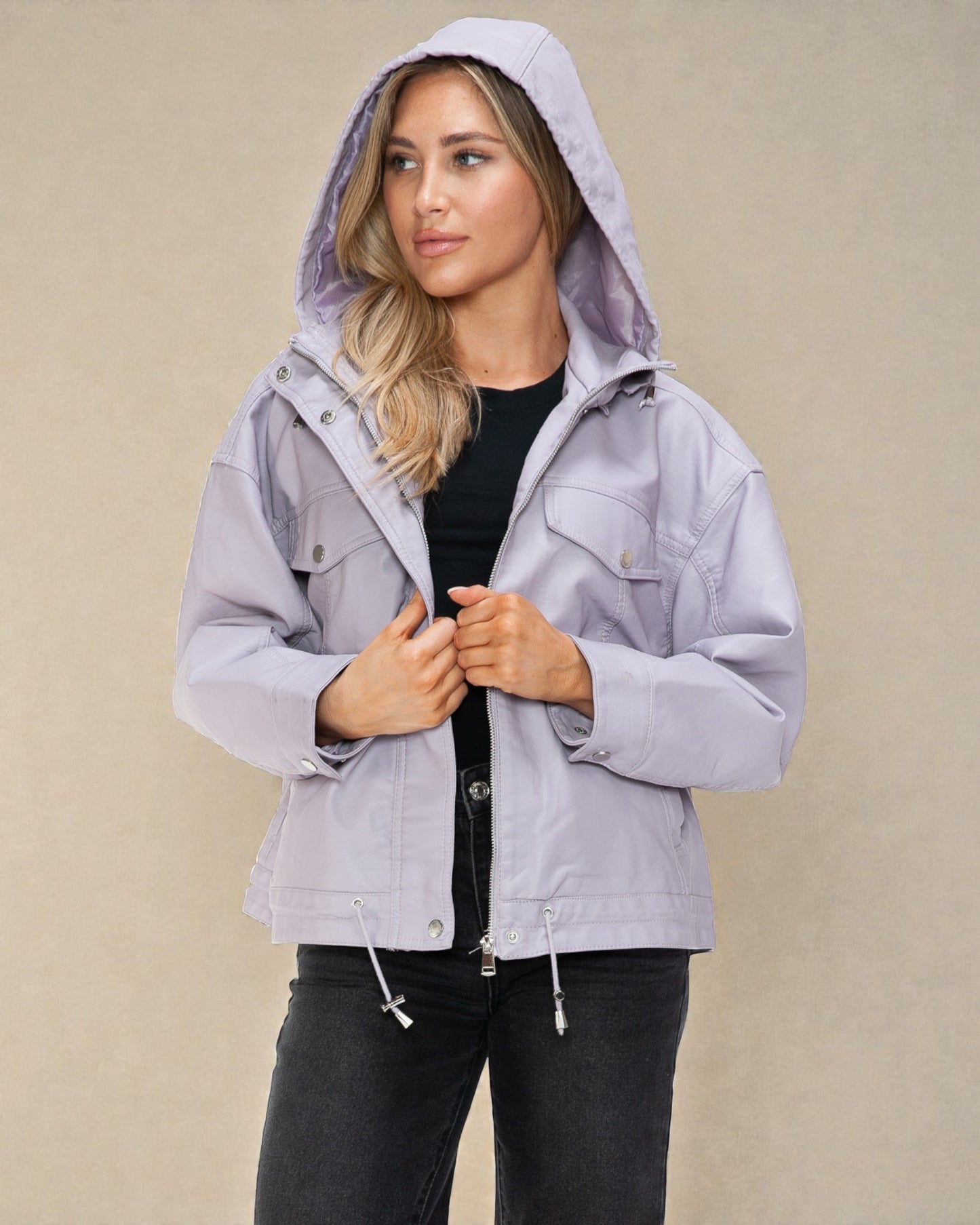 Woman wearing a light gray hooded jacket on a beige background