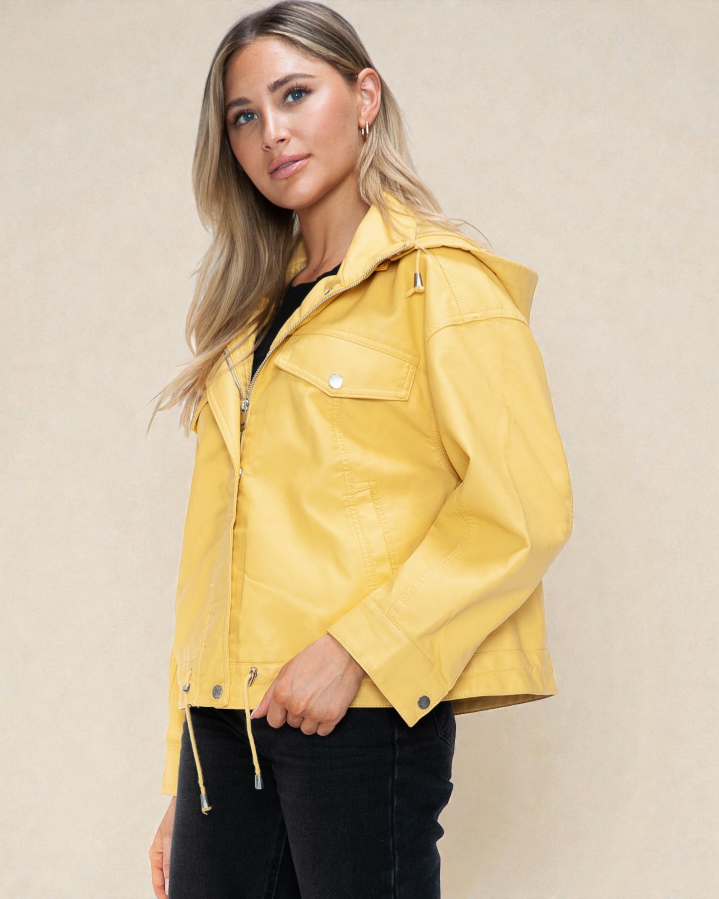 Woman wearing a yellow jacket against a beige background