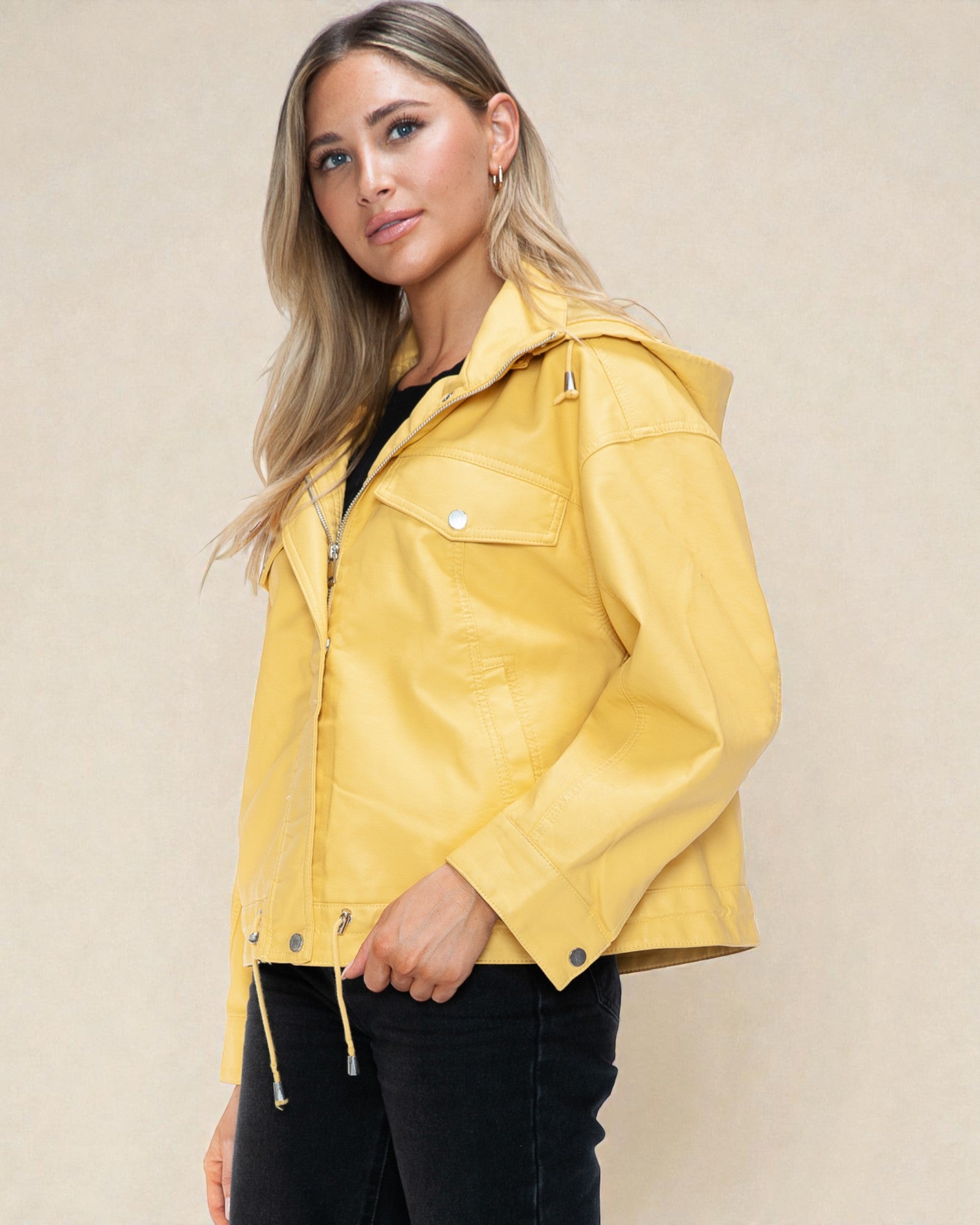 Woman wearing a yellow jacket against a beige background