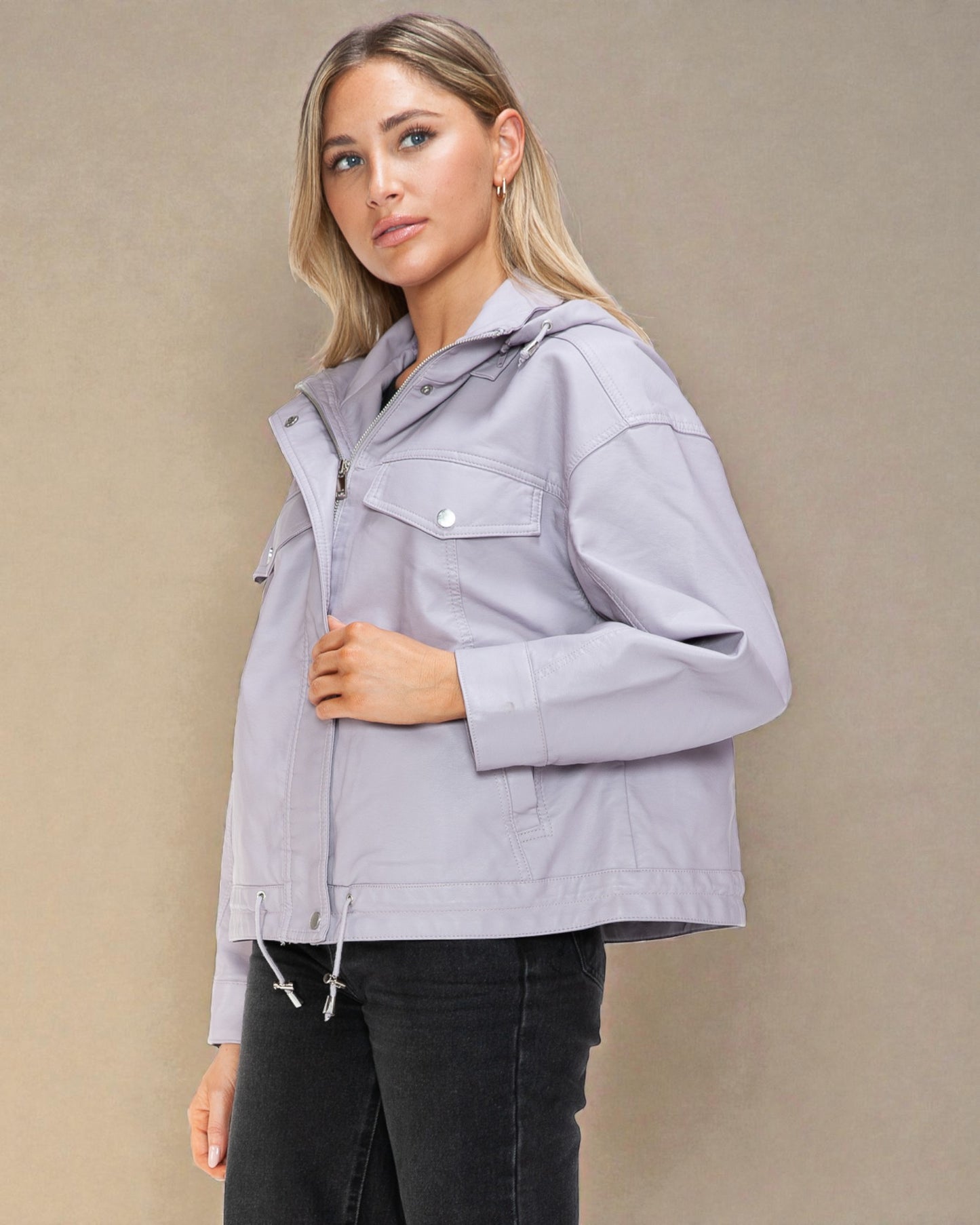 Woman wearing a light gray jacket against a beige background