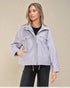 Woman wearing a light purple jacket against a beige background