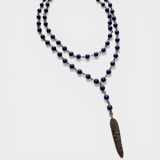 Blue beaded necklace with a feather pendant on a white background