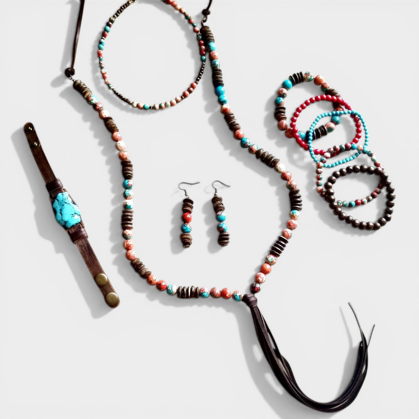 Jewelry set including necklaces, bracelets, and earrings with beads on a white background