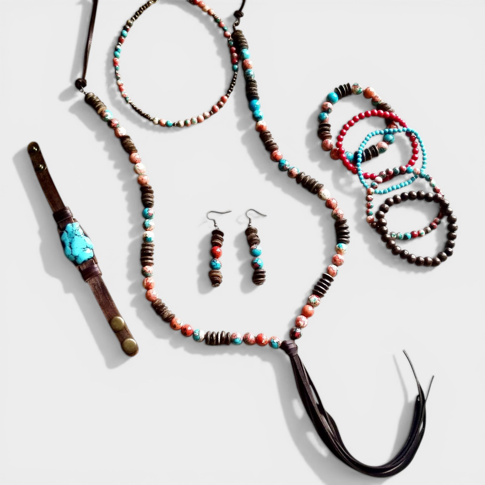 Jewelry set including necklaces, bracelets, and earrings with beads on a white background
