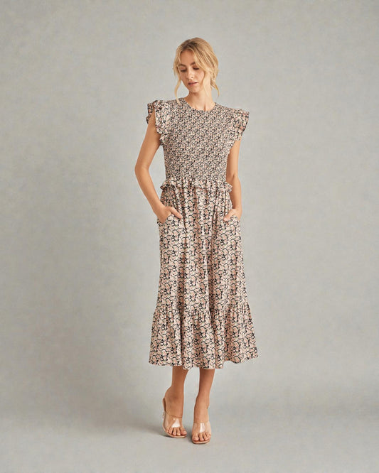 Woman wearing a patterned dress on a plain background