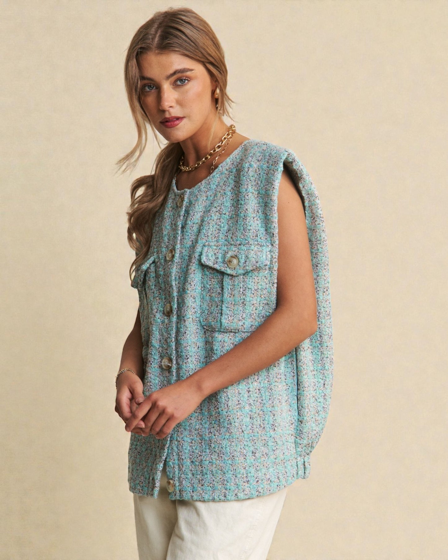 Woman wearing a patterned sleeveless top against a beige background