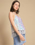 Woman wearing a sequin top with fringe details on a beige background