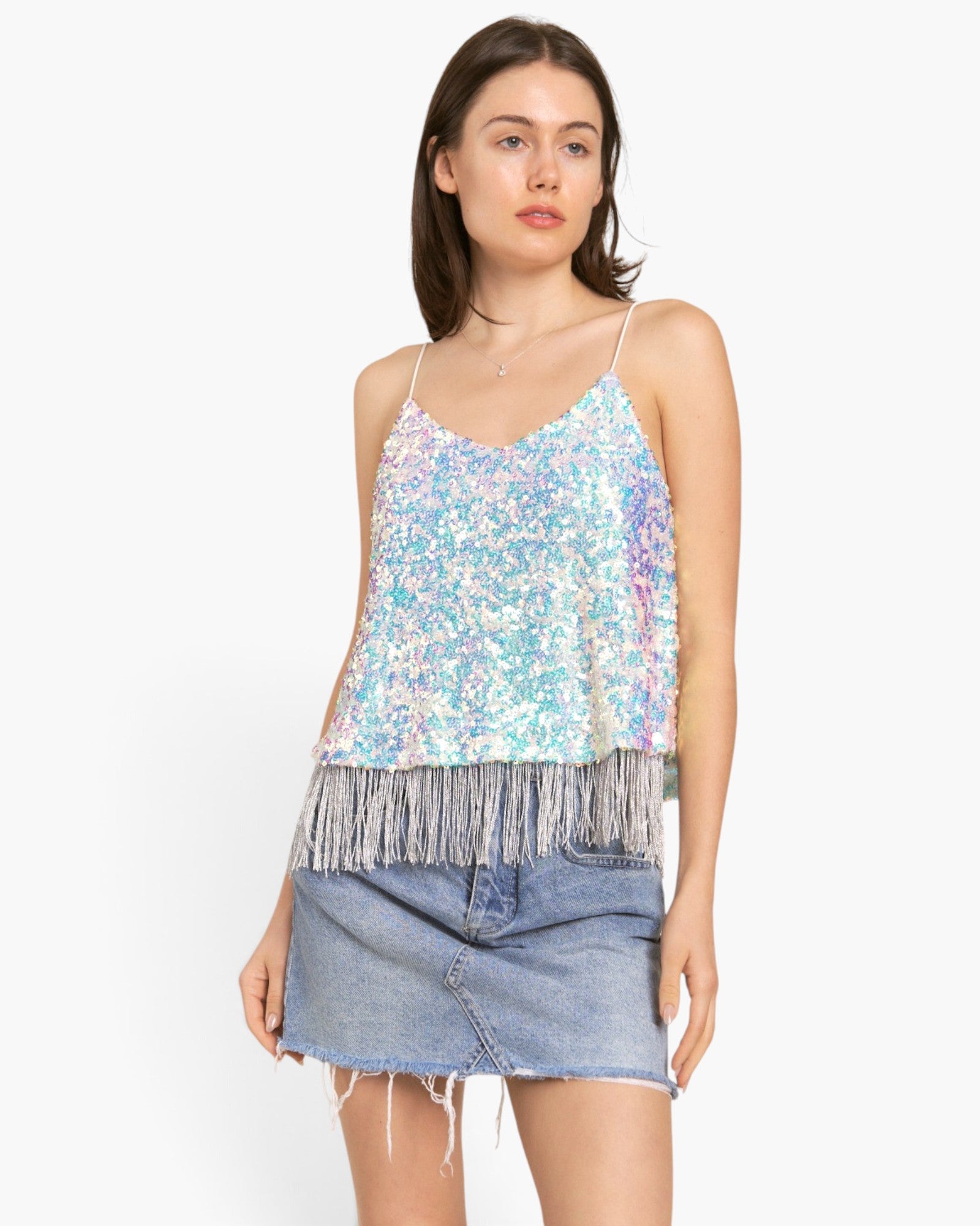 A model wearing a light blue sequined camisole top with silver fringe and a denim mini skirt, photographed against a clean white background.