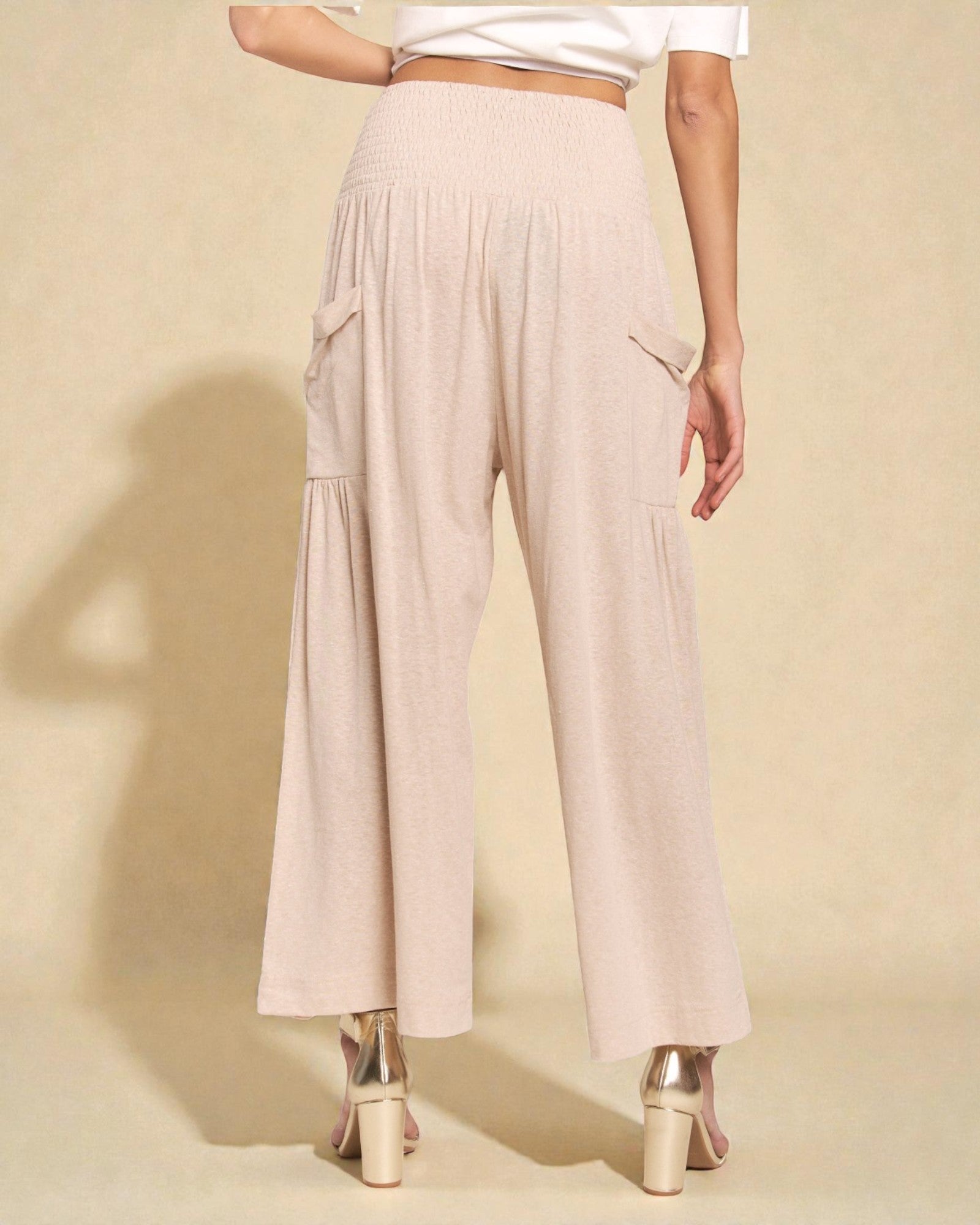 Beige wide-leg pants worn by a person on a beige background